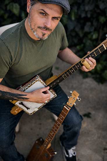 Jérôme Graille, musicien professionnel, jouant d'une Cigar Box Guitar 3 cordes